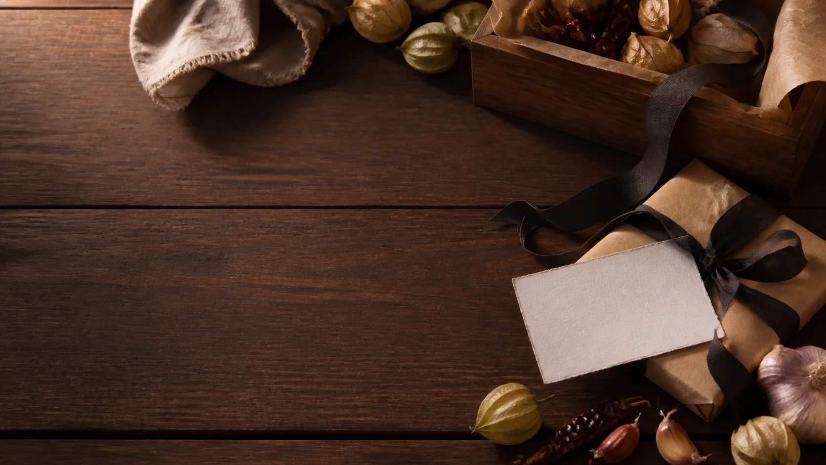 Mesa de regalo gourmet con caja de madera, papel kraft, listón y tarjeta en blanco